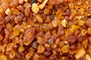 Tahtaya yerleştirilmiş küçük kehribar parçaları. Baltık reçinesinin değerli parçaları. Koyu arkaplan.