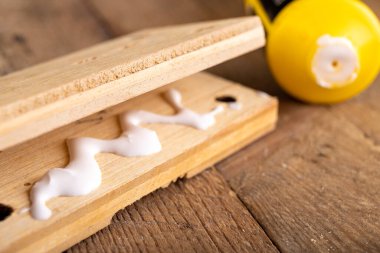 Ahşabı marangozluk yapıştırıcısıyla yapıştırıyorum. Küçük marangozluk bir ev atölyesinde çalışıyor. Hafif arkaplan.