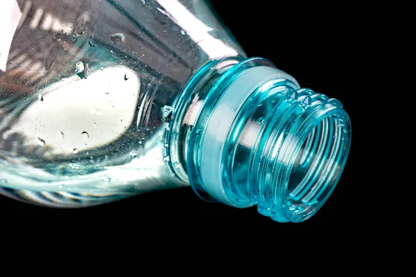 The neck of a plastic bottle. Water storage container. Dark background.