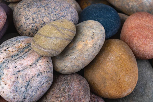 Dry oval stones found on the seashore. Stones carved by sea water. Dark background.