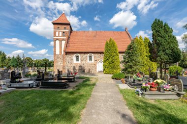 Kielbasin, Kujawsko-pomorskie / Polonya - 18 Ağustos 2020: Küçük bir köydeki kırmızı tuğla kilise ve mezarlık. Orta Avrupa 'daki Hristiyan tapınağı. Yaz mevsimi.