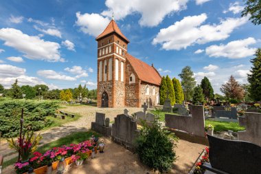 Kielbasin, Kujawsko-pomorskie / Polonya - 18 Ağustos 2020: Küçük bir köydeki kırmızı tuğla kilise ve mezarlık. Orta Avrupa 'daki Hristiyan tapınağı. Yaz mevsimi.