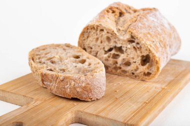 Mutfak tahtasının üzerinde taze dilimlenmiş çörek. Ekmek evde yemek için hazırlandı. Hafif arkaplan.