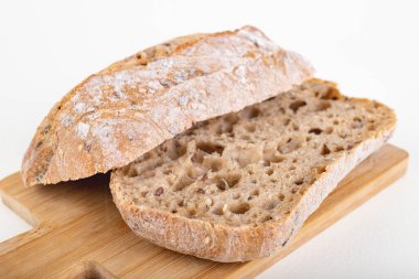 Mutfak tahtasının üzerinde taze dilimlenmiş çörek. Ekmek evde yemek için hazırlandı. Hafif arkaplan.