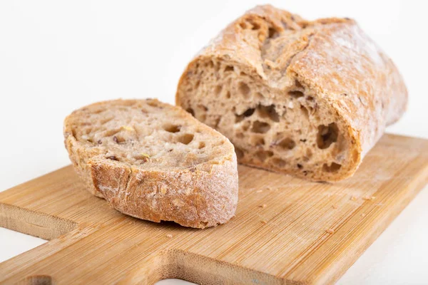 Mutfak tahtasının üzerinde taze dilimlenmiş çörek. Ekmek evde yemek için hazırlandı. Hafif arkaplan.