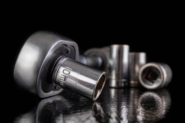 Metal soket anahtarlar ve cırcır. Atölyedeki krom tamir aletleri. Koyu arkaplan.