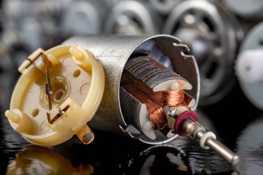 Küçük bir elektrikli motorun pervanesi. Elektrikli aletleri tamir etmek için elektrikli aksesuarlar. Koyu arkaplan.