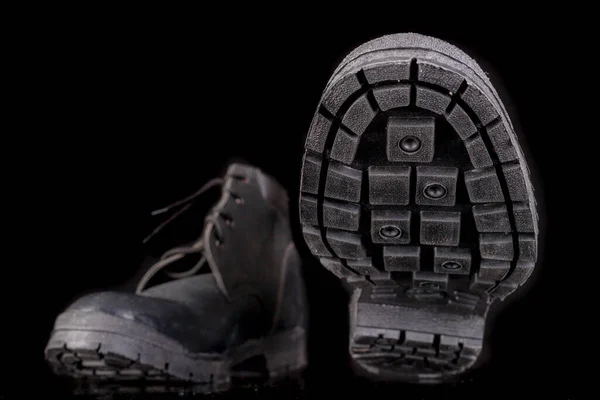 Work shoes with visible sole and tread. Footwear for a production worker. Dark background.