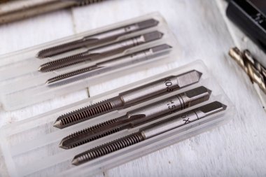 Metal musluklar iş için hazır. Çilingir atölyesindeki aksesuarlar. Hafif arkaplan.