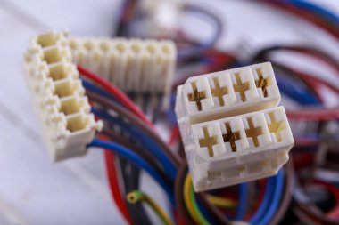 Elektrik kablolarına takılı plastik prizler. Cihaz ve bileşenleri bağlamak için elektrik konnektörleri. Hafif arkaplan.