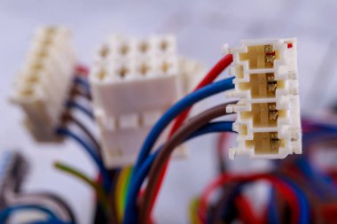 Elektrik kablolarına takılı plastik prizler. Cihaz ve bileşenleri bağlamak için elektrik konnektörleri. Hafif arkaplan.