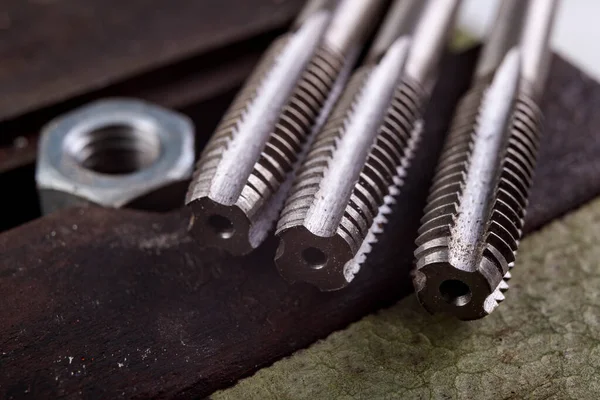 stock image Threading a metal nut in a vice. Minor locksmith work in the workshop. Light background.