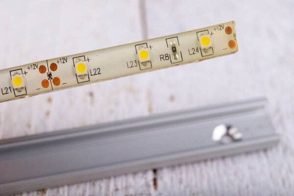 LED strip used to illuminate rooms in an aluminum strip. Electric accessories for self-assembly at home. Light background.