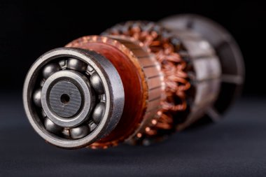 Karanlık bir masada elektrikli motor pervanesi. Motorların tamiri ve onarımı için aksesuarlar. Siyah arkaplan.