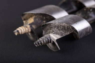 Tahtayı delmek için metal matkap uçları. Bir ev atölyesindeki marangozlar için aksesuarlar. Koyu arkaplan.