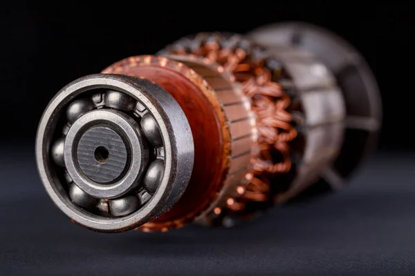 Electric motor rotor on a dark table. Accessories for overhaul and repair of engines. Black background.