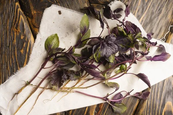 Birkaç dal taze fesleğen kaba doku eski bir ahşap masa beyaz bez peçeteyi yalan. Uzay kopyalayın. Reklam tasarımı. Mutfak, Restoran, yemek.