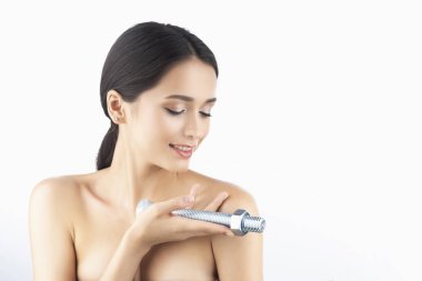 Güzel bir gülümseyen esmer kız çıplak omuz ile onun elinde büyük bir çelik cıvata bir fıstıklı tutar. Beyaz izole. Uzay kopyalayın. Reklam tasarımı. Sağlıklı cilt.