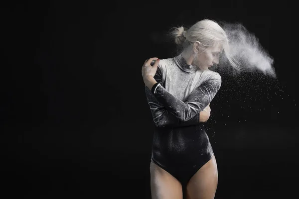 Beautiful slim girl wearing a black gymnastic bodysuit covered w — Stock Photo, Image