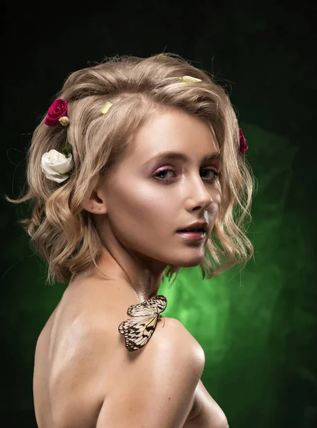 Beautiful smiling young blonde girl with flowers braided into he — Stock Photo, Image