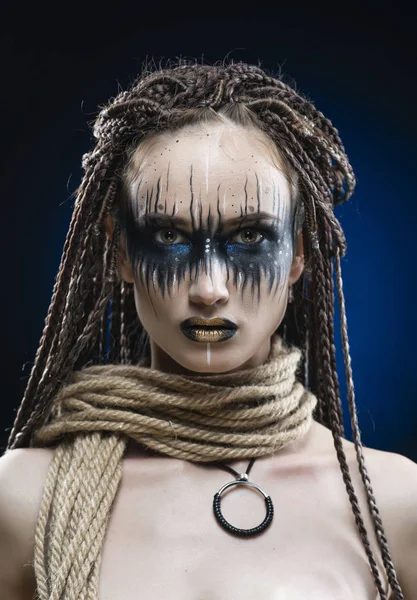 Een mooi jong slank meisje met avant-garde blauwe make-up en een — Stockfoto