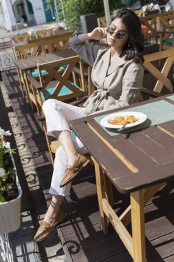 Güneş gözlüğü takan güzel gülümseyen esmer kız lun yaşıyor