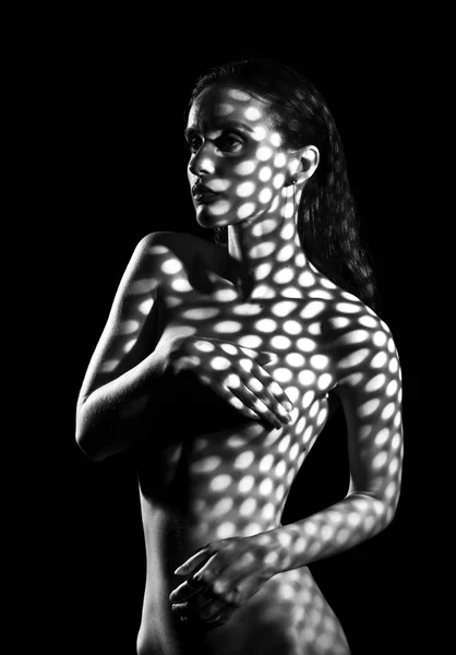 Обнаженная девушка-модель прикрыта теневой маской с множеством кнопок — стоковое фото