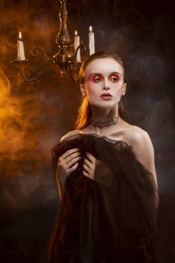 Güzel bir ince üstsüz kız, küpe ve kolye giyiyor, 