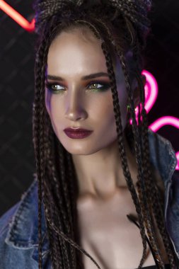 Bir afro cornrows ile güzel kız, kot ceket giyiyor, oturur 