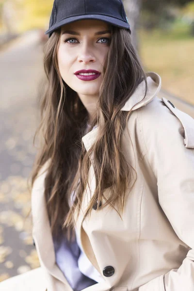 Une belle fille souriante portant un manteau léger, un jean et une plaie — Photo