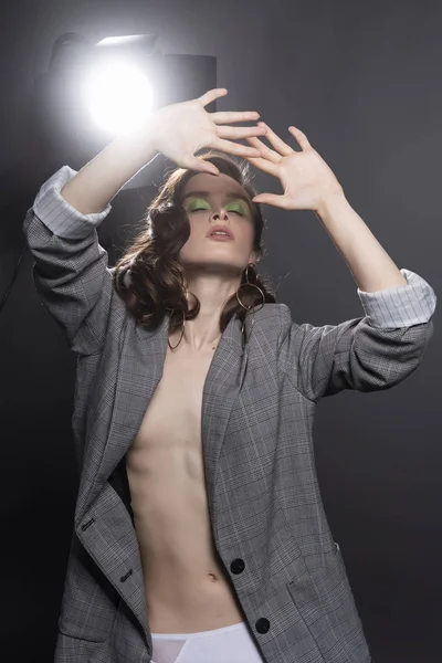 A beautiful topless girl wearing a gray unbuttoned oversized jac — Stock Photo, Image