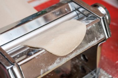 Hamuru haddeleme için metal krom un closeup ile toz masanın üzerinde bir makinedir