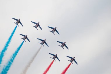 Rusya, Zhukovsky - 22 Ağustos 2009: Birkaç askeri uçak simetrik olarak çok renkli bir duman serbest akrobasi rakamlar gerçekleştirmek