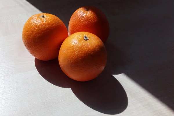 Τρία Πορτοκάλια Βρίσκονται Πάνω Στο Ξύλινο Τραπέζι Μορφή Ενός Τριγώνου — Φωτογραφία Αρχείου