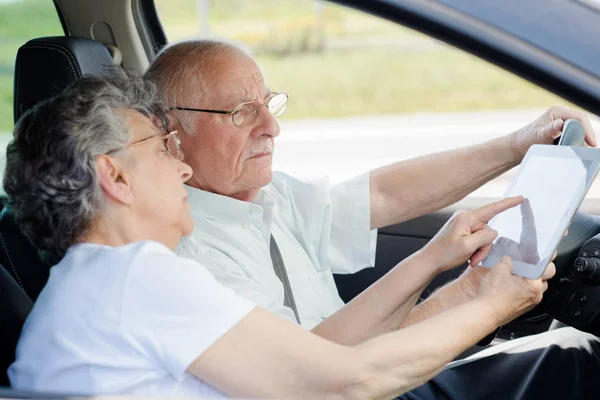 Счастливая пожилая пара сидит внутри автомобиля — стоковое фото
