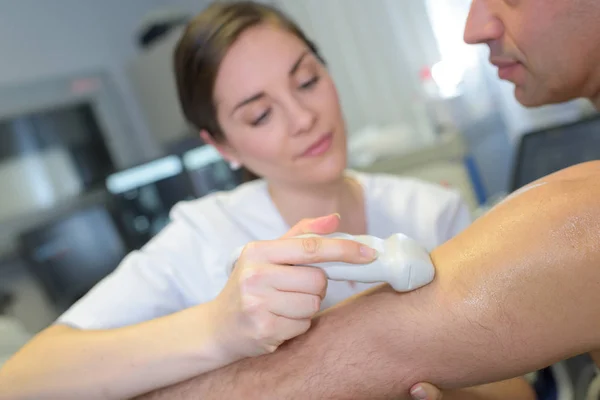 Médico femenino con paciente masculino sometido a ecografía de brazo — Foto de Stock