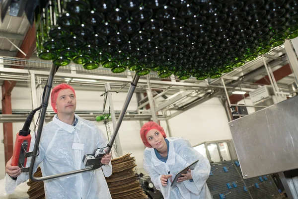 Twee ernstige werknemers doen hun werk op de fabriek productielijn — Stockfoto