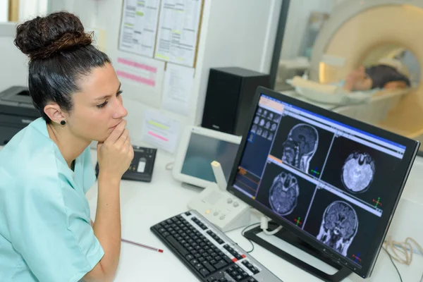 Médico feminino olhando para o paciente submetido a tomografia computadorizada — Fotografia de Stock