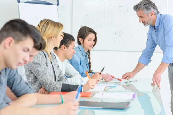 Profesor y estudiantes en un aula — Foto de Stock