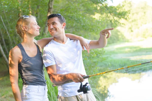 Jovem casal pesca nas margens da lagoa — Fotografia de Stock