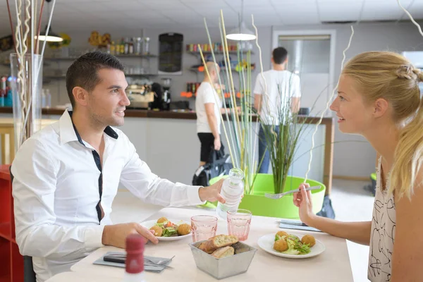 Šťastný mladý pár spolu jíst v restauraci — Stock fotografie