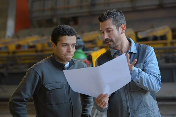 Mellomalderflygeleder som tilbyr arbeidsavtale på fabrikk – stockfoto