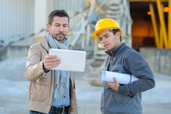 Manager is holding a tablet next to his colleague — Stock Photo, Image