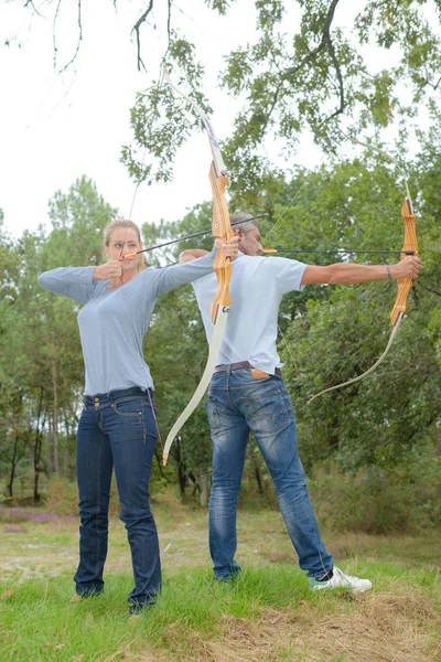 Joven pareja tiro con arco practicar — Foto de Stock