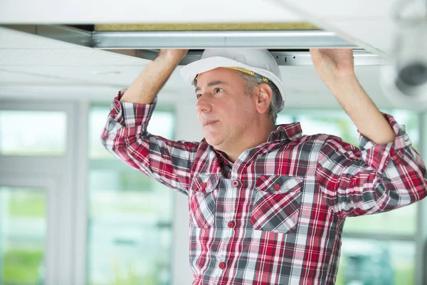 Bauunternehmer ersetzt Deckenplatte — Stockfoto