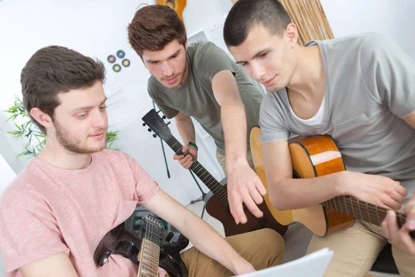 Молоді чоловіки грають на гітарі в світлій кімнаті — стокове фото