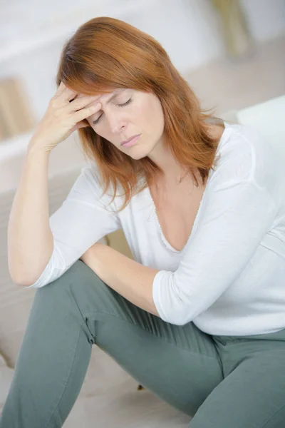 Mujer que sufre de dolor de cabeza en casa — Foto de Stock
