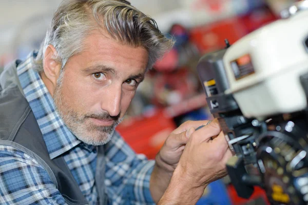 Nahaufnahme eines Mechanikers, der an einem Benzinmotor arbeitet — Stockfoto