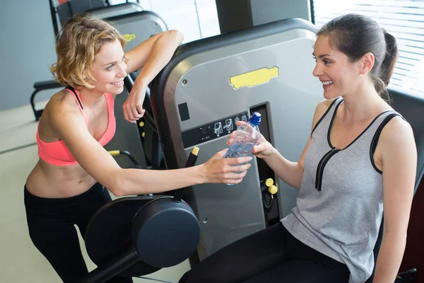 运动妇女饮水在健身房举行的瓶子有打破 — 图库照片