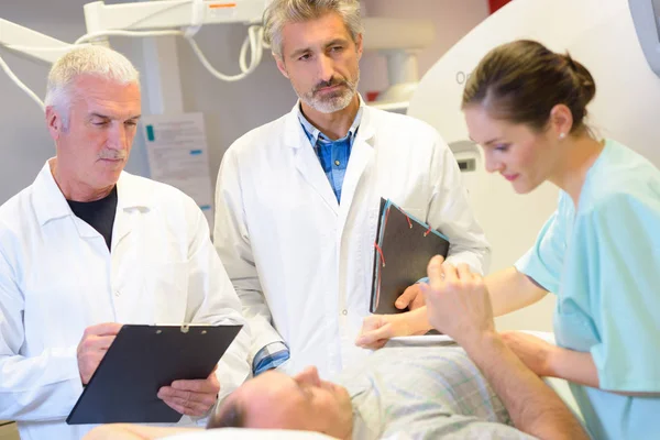 Médicos y enfermeros revisando al paciente en el hospital — Foto de Stock